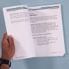 MathBuilders Unit 6 internal pages with hand holding the page