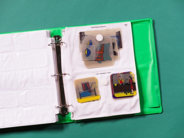 A pocket page that is divided in half vertically contained in a green binder. The top half contains a set of Three Bears overlays; the bottom half, two sets of logic sequence cards.
