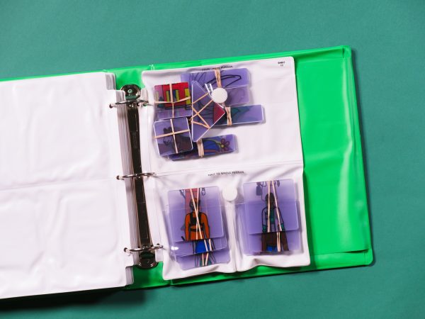 A pocket page that is divided in half vertically contained in a green binder. The top half contains four piece puzzle sets; the bottom half, two half-to-whole puzzle sets.