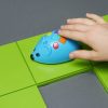 A child's hand moves the blue Code and Go Mouse along a row of lime green squares.