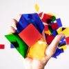 LED mini light box parquetry pieces. A hand holding several translucent, colorful pieces.