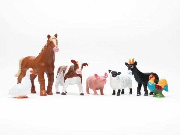 a row of a plastic 3-D animal miniatures including a duck, horse, cow, pig, sheep, goat, and a rooster.