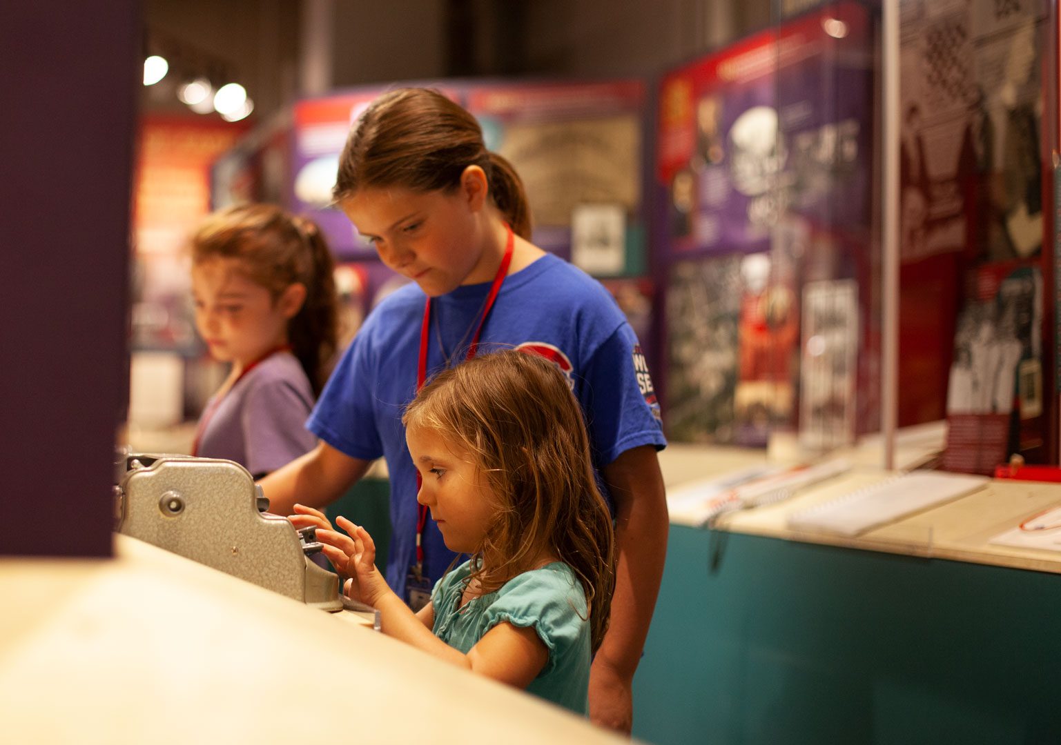 Two young girls examine a mechanical brailler on display in the APH Museum.