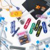 An array of BRIC: Structures kit components strewed out on a white surface. Pictured are building blocks, a base plate, several switches and other electrical components, snaps, and a variety of cables.