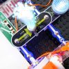 A close up of a BRIC: Structures project build on a black base plate. The project involves connecting a battery source to several small light components.
