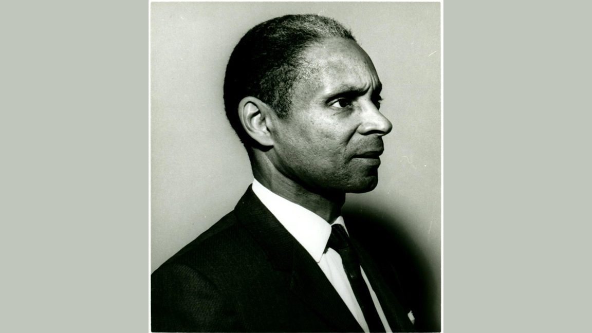 Head and shoulders portrait of a middle-aged Black man wearing a suit and tie.