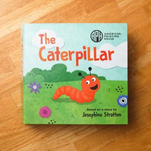The Caterpillar book based on a story by Josephine Stratton. Front cover illustration shows the orange caterpillar crawling across a bright green field with flowers and bushes and a blue sky.