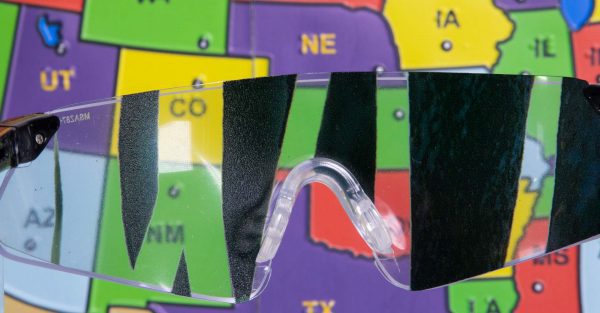 Close up of safety glasses containing the Detached Retina insert in front of a tactile map of the United States. This image gives an idea of how an individual with Detached Retina would see the map.