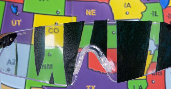 Close up of safety glasses containing the Detached Retina insert in front of a tactile map of the United States. This image gives an idea of how an individual with Detached Retina would see the map.