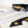 A pair of safety glasses containing the Glaucoma insert sits on top of a printed page with information about the condition and an image of the insert laid flat