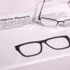 A pair of safety glasses containing the Myopia insert sits on top of a printed page with information about the condition and an image of the insert laid flat