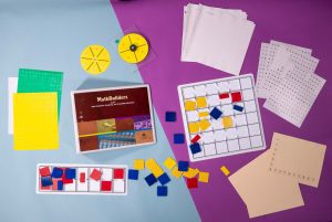 Bird's eye view of MathBuilders Unit 8 Kit: Data Collection, Graphing, and Probability/Statistics spread out to show the kits’ components including tactile graphing squares, embossed graph sheets, Feel ‘n Peel Stickers, a guidebook, and more.