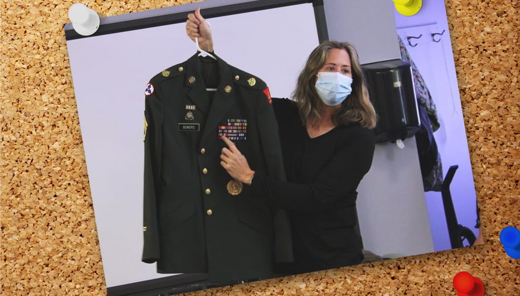 A photo pinned to a cork board of Megan in a face mask holding a military jacket.