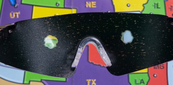 Close up of safety glasses containing the Retinitis Pigmentosa insert in front of a tactile map of the United States. This image gives an idea of how an individual with Retinitis Pigmentosa would see the map