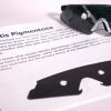 A pair of safety glasses containing the Retinitis Pigmentosa insert sits on top of a printed page with information about the condition and an image of the insert laid flat
