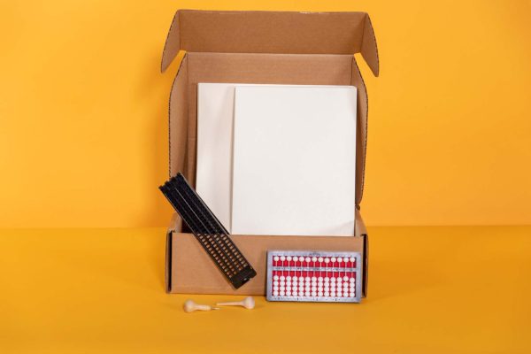 student starter pack box containing abacus, transcribing paper, and cell slate with saddle stylus