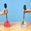 Two students each holding a SALS probe with the tip immersed in a flask filled with colored fluid on the left and clear fluid on the right.