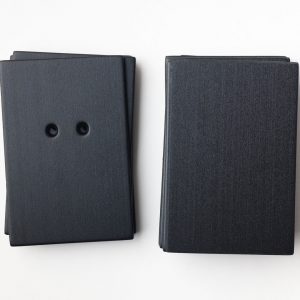 A package of black rectangle-shaped cards (10 undrilled and 5 two-hole drilled)