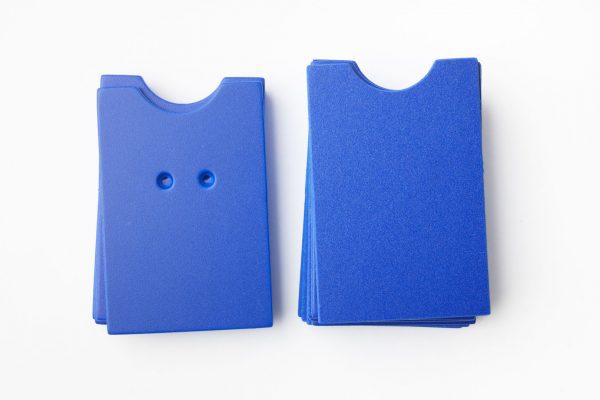 A package of blue “puzzle”-shaped cards (10 undrilled and 5 two-hole drilled)