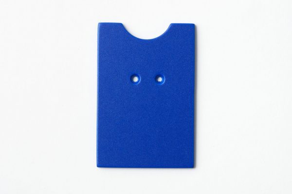 Single, two-hole drilled blue “puzzle”-shaped card