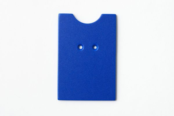 Single, two-hole drilled blue “puzzle”-shaped card