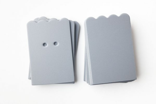 A package of gray scalloped-shaped cards (10 undrilled and 5 two-hole drilled.