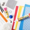 Accessories with Caulk replacement item for Tactile Connections: Symbols for Communication with assorted items including a variety of mounting cards in seven different colors and shapes, print guidebook, caulk tube, orange zipper, black and white spoons, fishing lure, steel washer, yellow puff ink, jingle bells, blue crescent shape, blue rubber ball, craft foam sheets (red, yellow, and blue), white needlepoint canvas, black plastic wire screen, adhesive-backed paper, vinyl sheets, and white hook coins/tabs.
