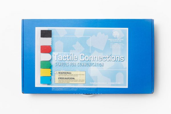 A fluted cardboard carrying box with handle for the APH’s Tactile Connections: Symbols for Communication. A Small Parts Choking Hazard label appears on the box in both print and braille, as well as the title of the product.
