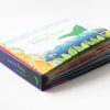 A Tail for Baby Lizard” storybook resting on the back cover. The spine of the book is navy blue and reads, “A Tail for Baby Lizard” in green, with an image of baby lizard at the bottom of the spine also in green.