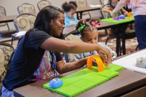 A mother demonstrating Code and Go Mouse for her daughter.