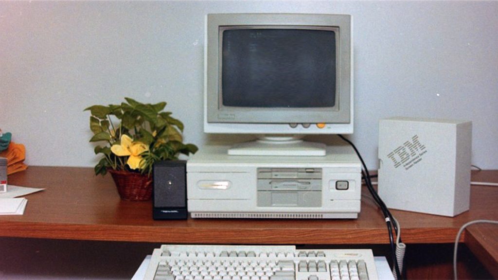 A photo from the 70s that shows an IBM personal computer sitting on a desk.