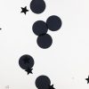Close up of a black swirly mat. Black stars and circles are shown inside the mat.