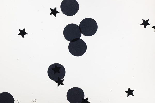 Close up of a black swirly mat. Black stars and circles are shown inside the mat.