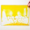 Zoomed out image of a yellow swirly mat over a white background.