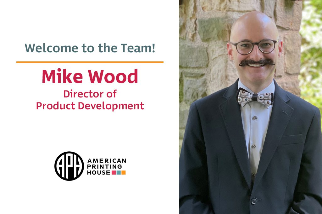 Portrait photo of Mike. He has a curled mustache and is wearing a bowtie patterned with eye balls. Text reads "Welcome to the team! Mike Wood, Director of Product Development." APH Logo.