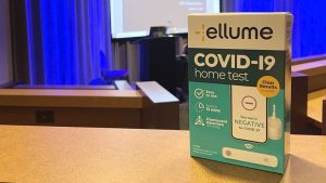An Ellume Covid 19 test in the box sits on a table in a conference hall.
