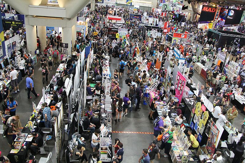 A photo from above of the a big crowd at a comiccon convention in a big convention hall.