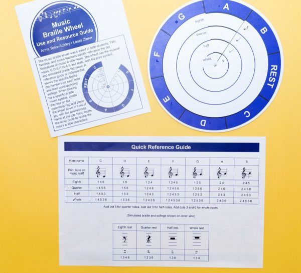 Overhead view of the complete Music Braille Wheel Kit, including the physical wheel, Use and Resource Guide, and the Quick Reference Guide.