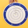 The Music Braille Wheel has a blue outer ring and four white inner rings displayed over a yellow background. The wheel consists of five rings or sections in total. The outer most section shows the notes: C, D, E, F, G, A, B, and rest in large print and braille. The inner rings in order from outward to inward show print and braille for eighth, quarter, half, and whole notes in print and braille for each of the notes listed in the outer ring.