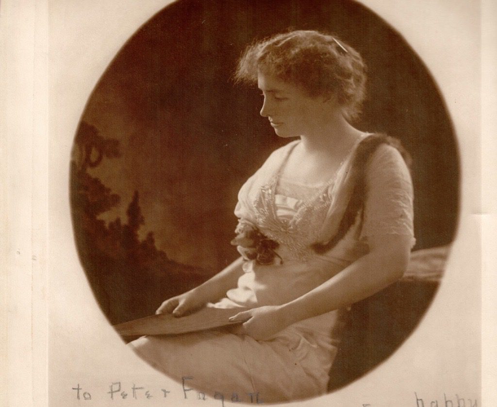 A photo of Helen Keller as a young woman. She is reclining on a chair.