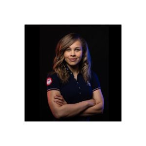 Amanda Dennis poses with her arms crossed while wearing a Team USA Paralympic branded shirt.