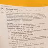 Close up of a hand holding a page in the Rules of UEB large print binder. The information on the page pertains to differences between single and double quotation marks.