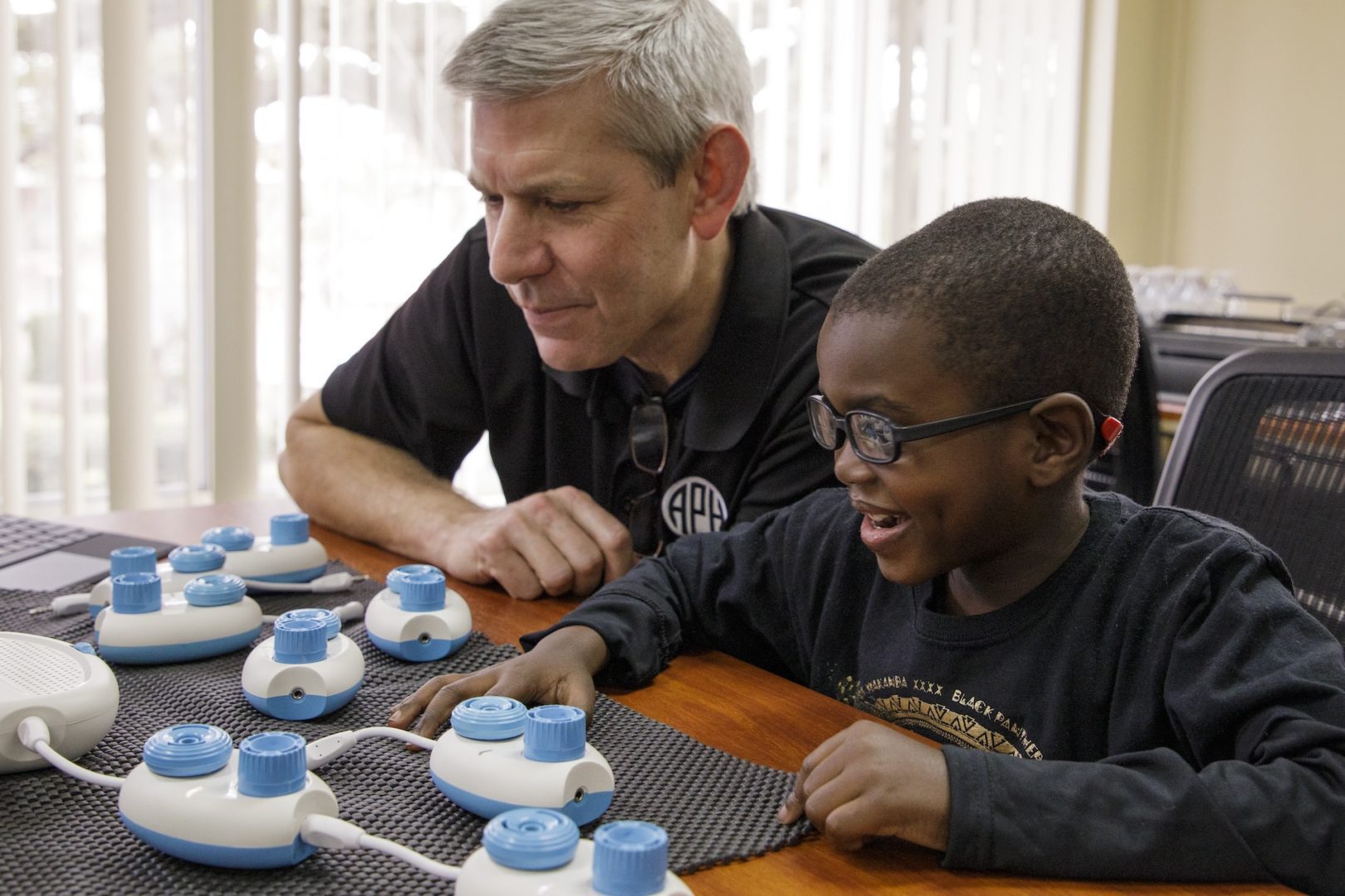 Teacher and student sitting at a table using CodeJumper