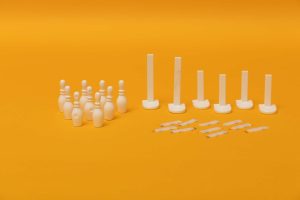 12 bowling pins arranged in a triangle, an assortment of goal posts, and several loop strips laid out on a yellow background.