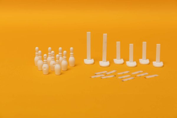 12 bowling pins arranged in a triangle, an assortment of goal posts, and several loop strips laid out on a yellow background.