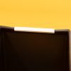 A close up image of the white U-channel attached to a black calendar box against a yellow background.