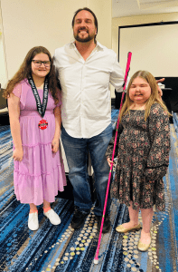 Joe Strechay smiles as he poses for a photo with two smiling abaacus bee competitors.