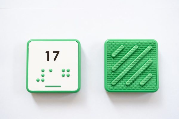 Close up comparison of the front and back of a green square UEB Reach and Match number tile showing the number 17 in braille and print. The back of the piece is textured.