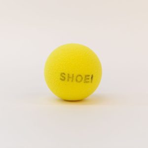 A yellow tennis ball with the word "SHOEI" printed in black