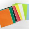 A stack of multi-colored textured paper spread across on a white surface.